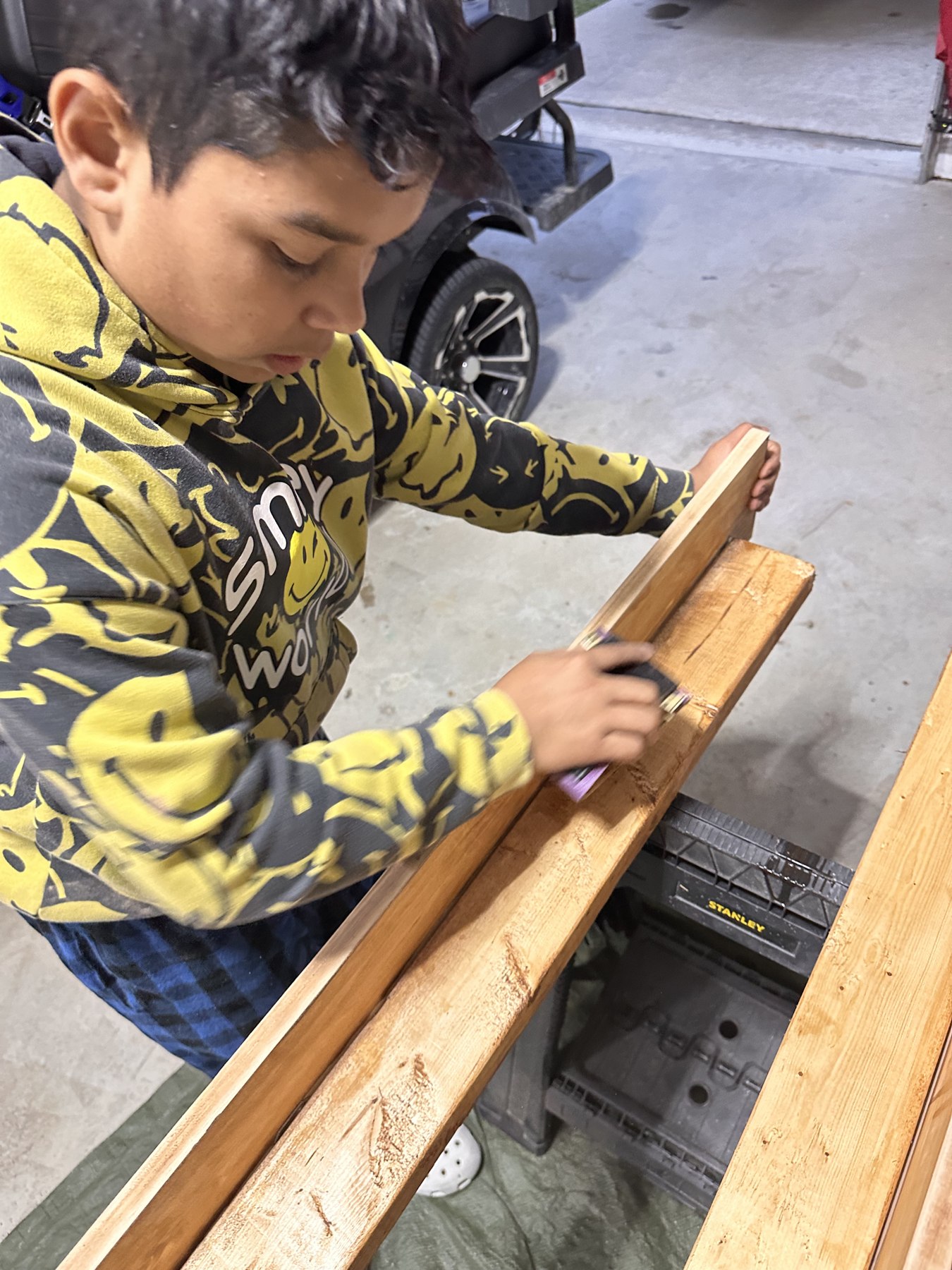 Josiah concentrating on a hands-on woodworking project